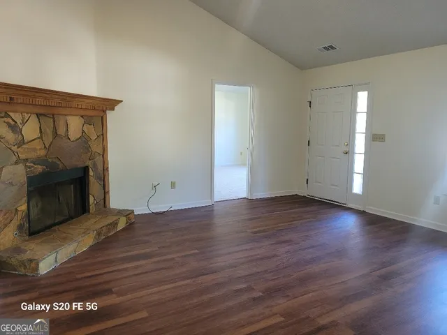 a view of empty room with wooden floor and fireplace
