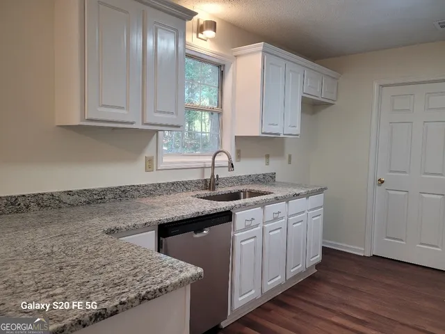 a kitchen with stainless steel appliances granite countertop a sink stove and cabinets