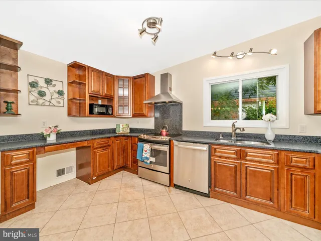 a kitchen with stainless steel appliances granite countertop a sink and cabinets