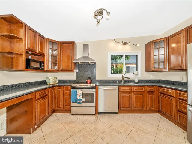 a kitchen with stainless steel appliances granite countertop a sink and cabinets
