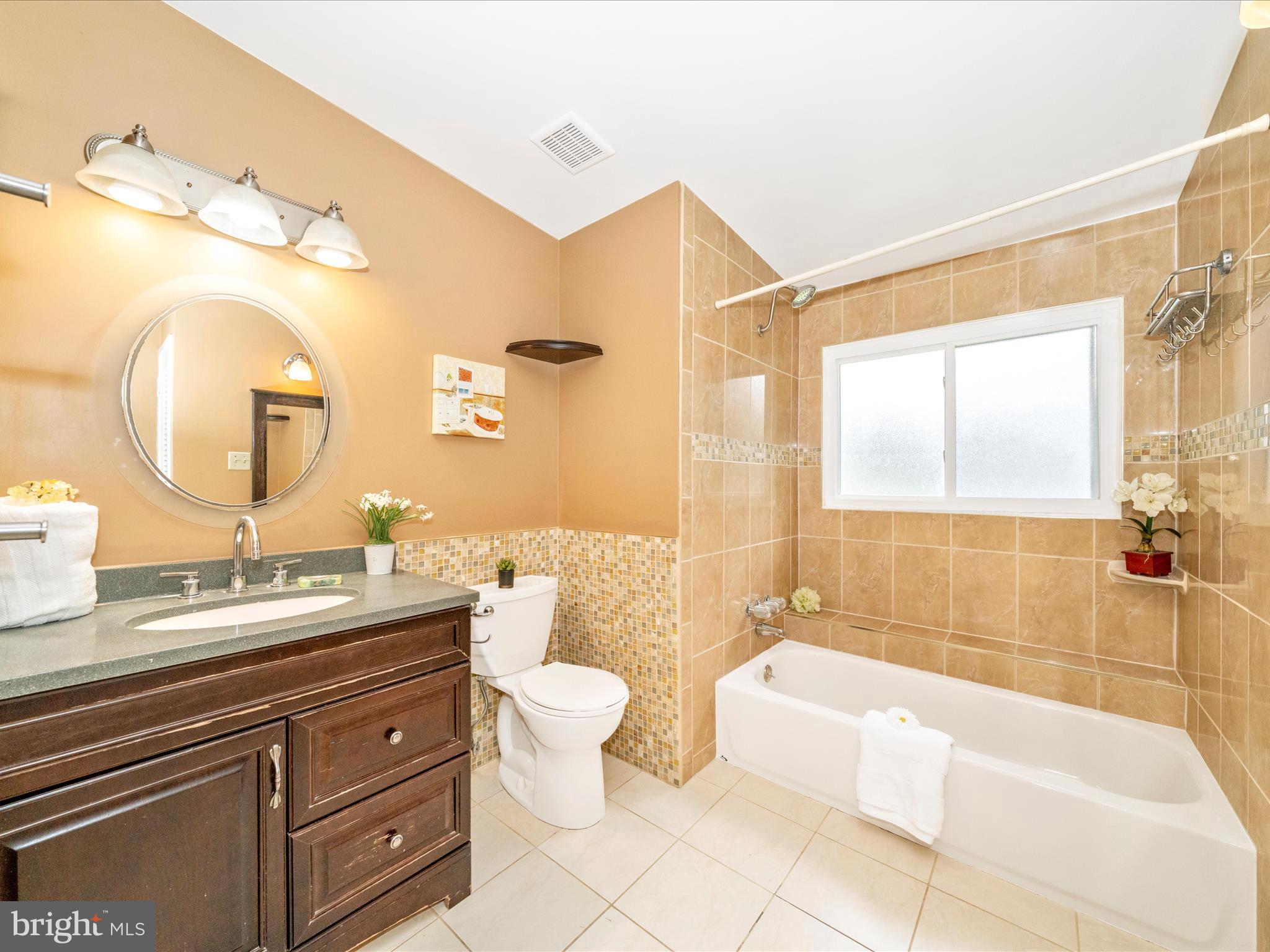 3313 Estelle Terrace Silver Spring, MD 20906 - Photo 34 of 52 a bathroom with a double vanity sink a toilet a mirror and bathtub