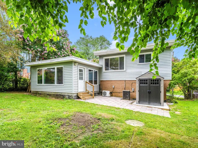 a view of a house with backyard and a tree