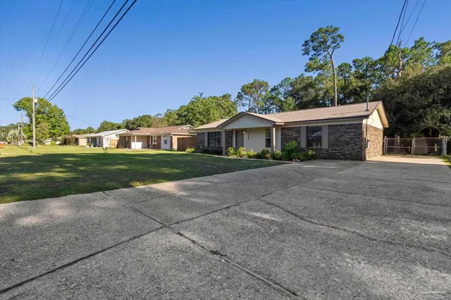 a front view of a house with a yard and potted plants