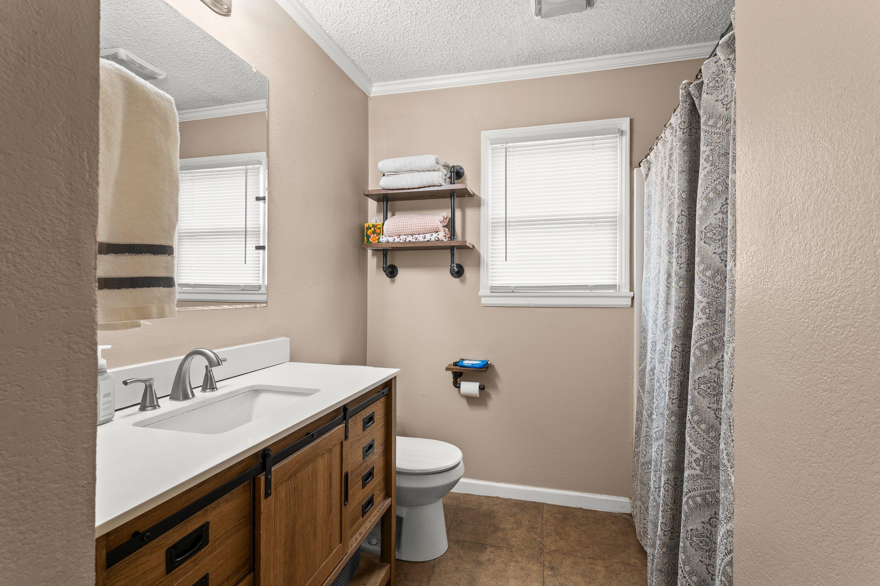 505 East 15th Street Littlefield, TX 79339 - Photo 11 of 22 a bathroom with a sink a toilet and shower