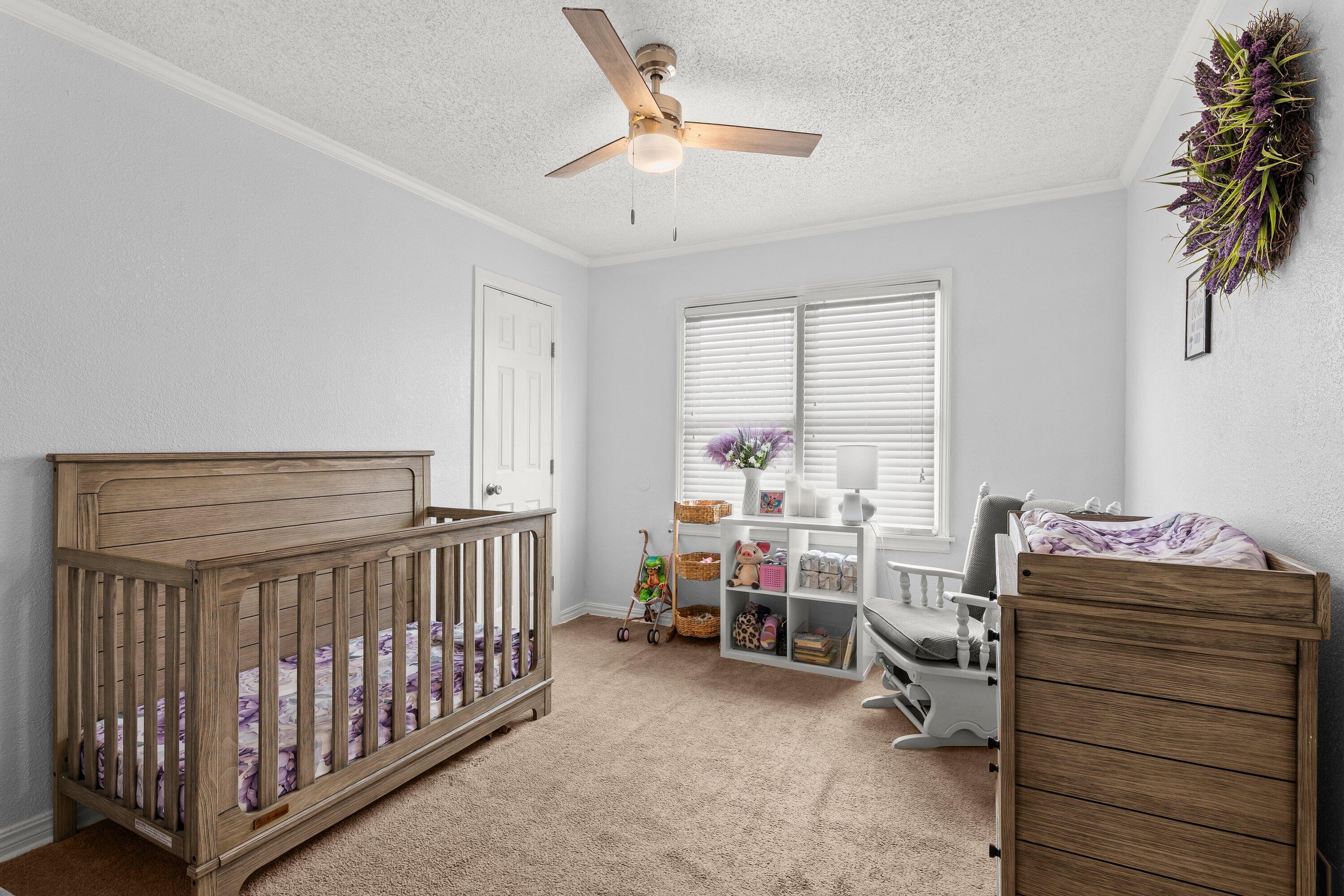 505 East 15th Street Littlefield, TX 79339 - Photo 12 of 22 a bedroom with a baby bed a desk and chair with the bedroom