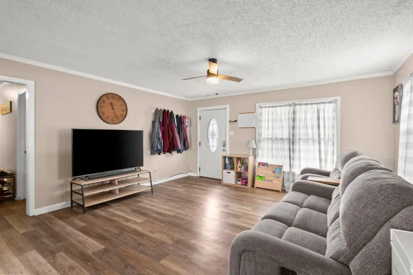 a living room with furniture gym equipment and a flat screen tv