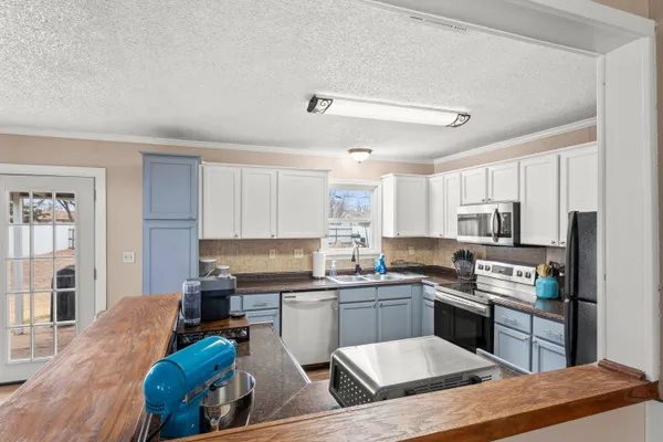 a kitchen with stainless steel appliances kitchen island granite countertop a sink and cabinets