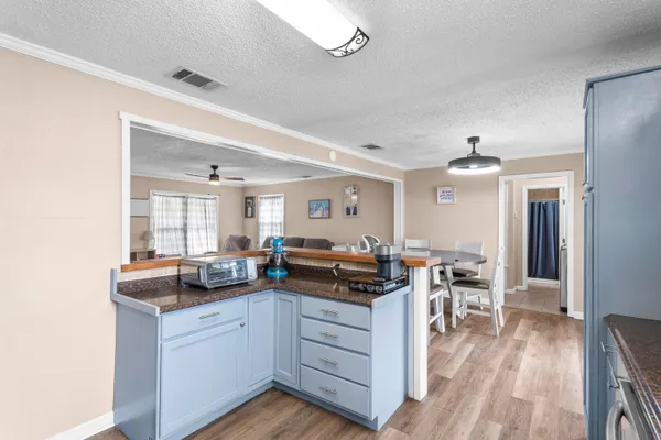 a kitchen with counter top space and wooden floor