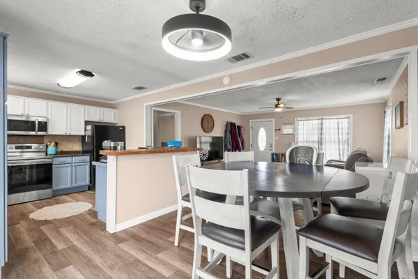a kitchen with a dining table cabinets appliances and a window