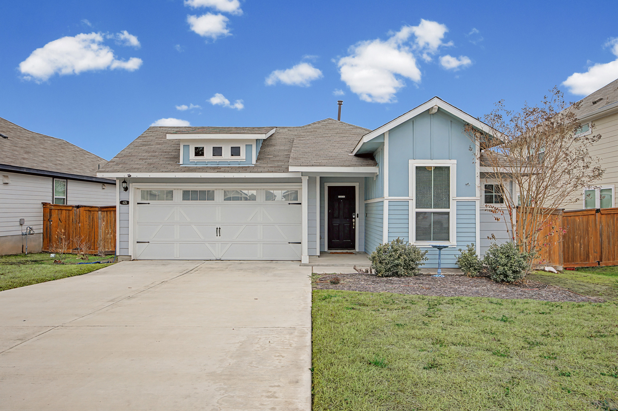 View of front of property featuring concrete driveway, roof with shingles, board and batten siding, and an attached garage