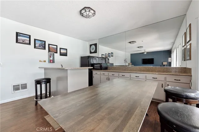 a kitchen with a table chairs refrigerator and cabinets