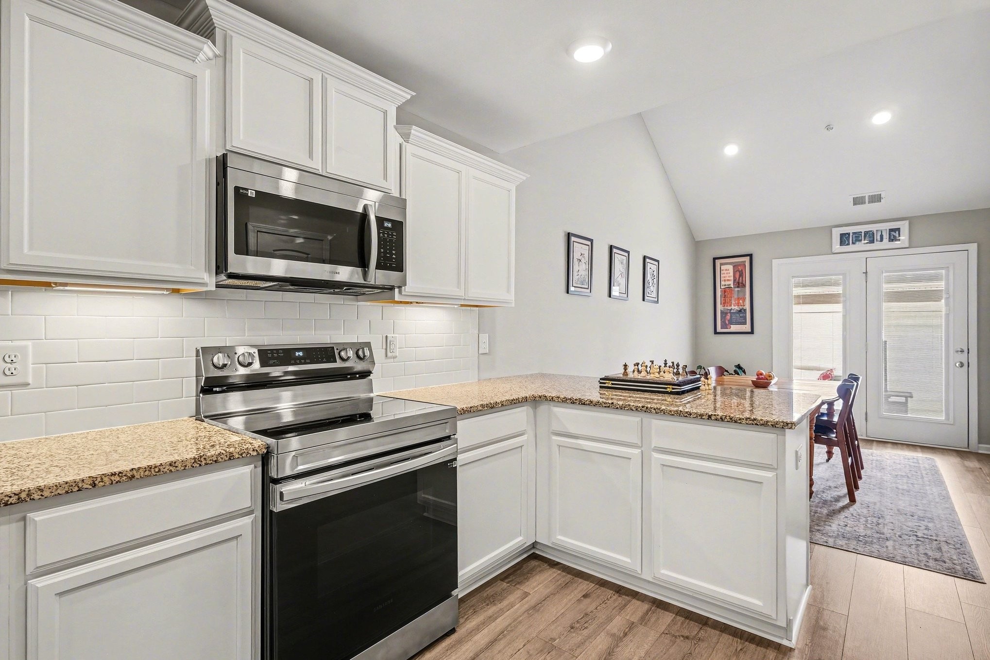 381 Ezra Street Pleasant View, TN 37146 - Photo 12 of 31 a kitchen with stainless steel appliances granite countertop a stove top oven a sink dishwasher and white cabinets
