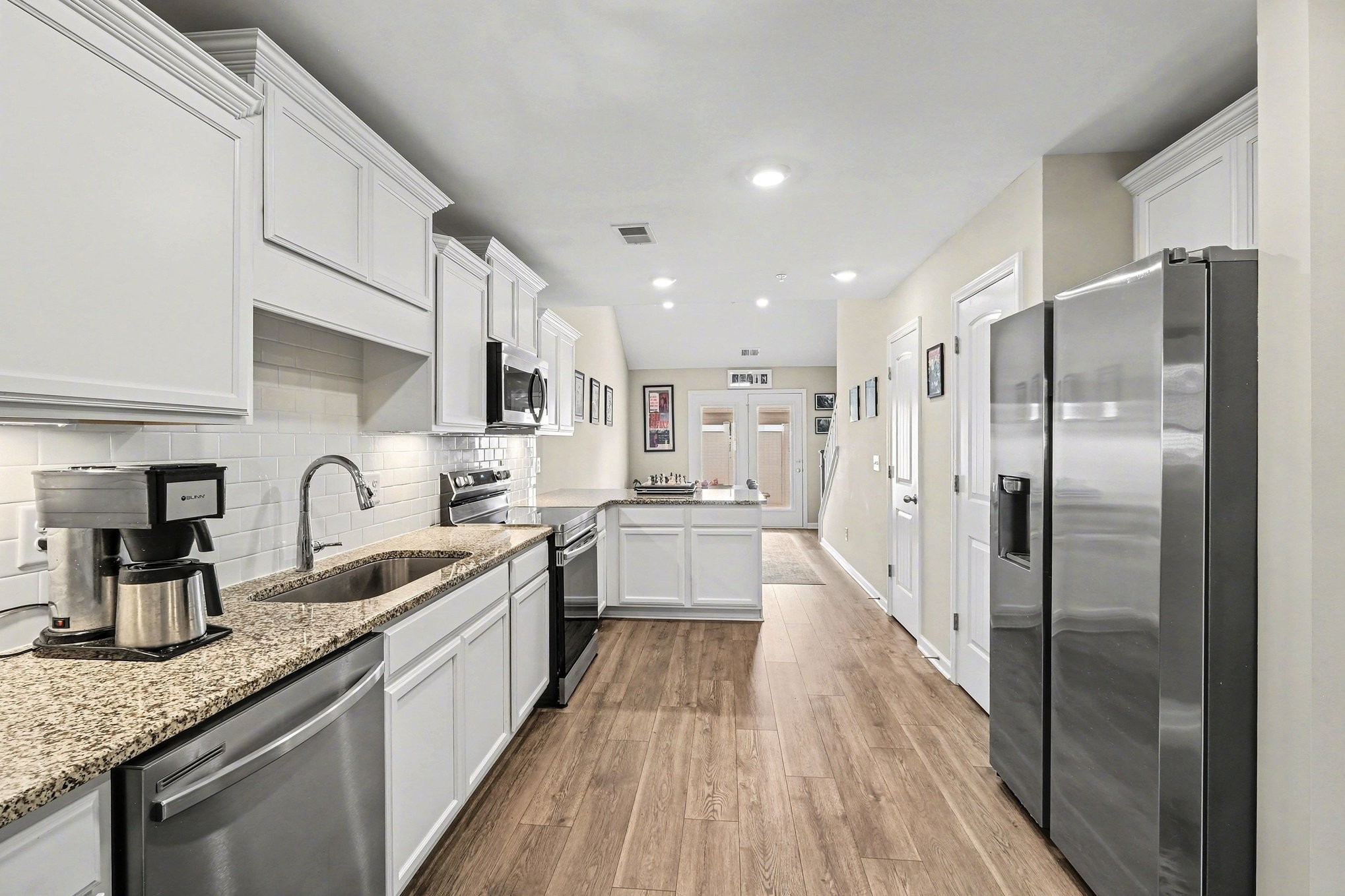 381 Ezra Street Pleasant View, TN 37146 - Photo 9 of 31 a large kitchen with stainless steel appliances granite countertop a refrigerator a sink a stove and a wooden floors