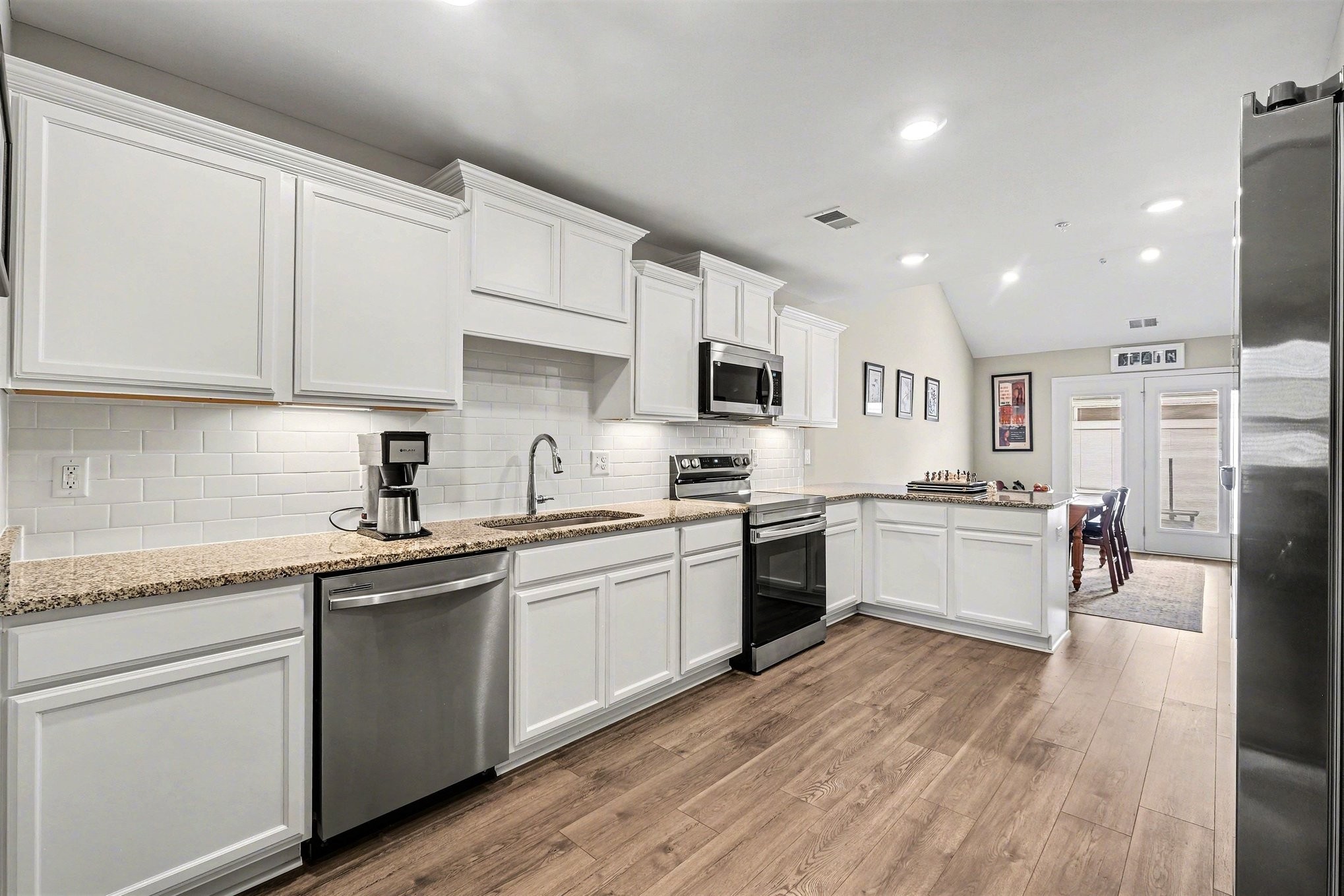 381 Ezra Street Pleasant View, TN 37146 - Photo 10 of 31 a kitchen with stainless steel appliances granite countertop refrigerator sink and white cabinets