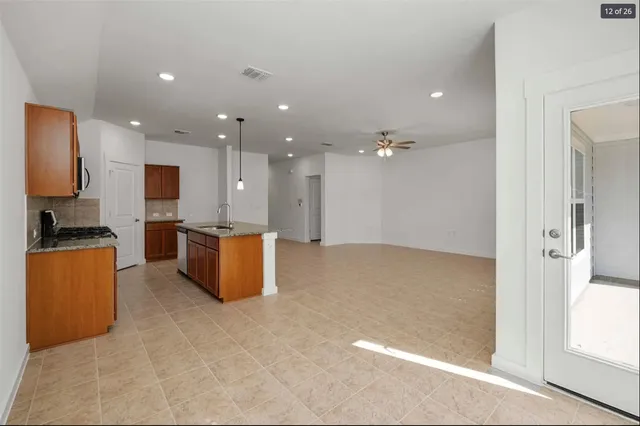 a open kitchen with kitchen island granite countertop a refrigerator and a stove top oven