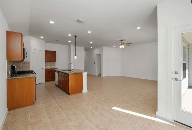 a view of kitchen with kitchen island stainless steel appliances counter top space and living room