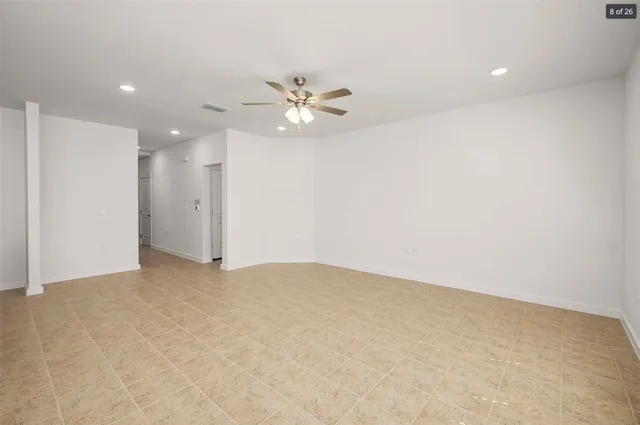 an empty room with a window and a ceiling fan