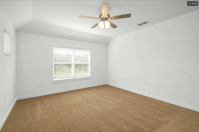 an empty room with windows and fan