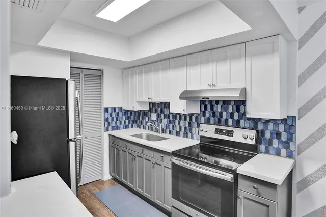 a kitchen with stainless steel appliances granite countertop a stove and a refrigerator