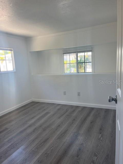 10315 Cortez Road West, Unit 1B Bradenton, FL 34210 - Photo 11 of 48 an empty room with wooden floor and windows