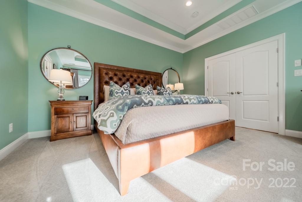 104 Maddaket Loop Mooresville, NC 28117 - Photo 24 of 45 a bed sitting in a bedroom next to a window and a chandelier