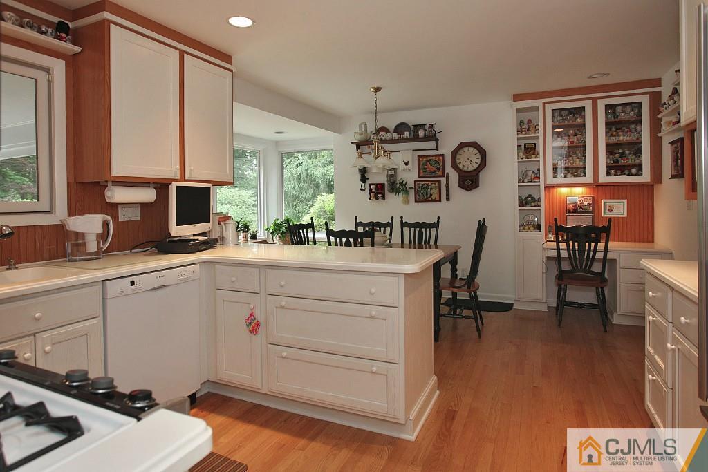 25 Clive Hills Road Edison, NJ 08820 - Photo 16 of 25 a kitchen with a sink a stove and a dining table with wooden floor