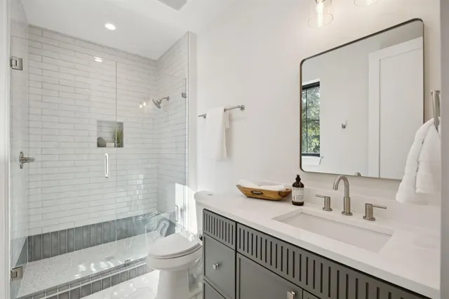 a bathroom with a sink a toilet and shower