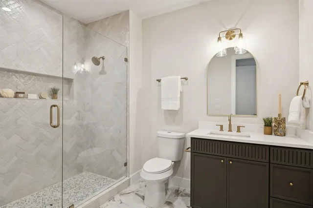 a bathroom with a sink a toilet and shower
