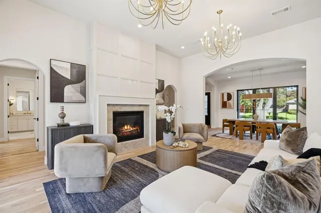 a living room with furniture chandelier and a fireplace