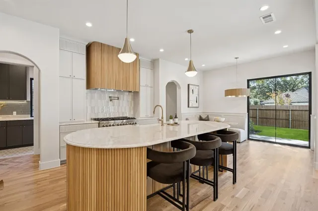 an open kitchen with granite countertop a sink cabinets and wooden floor
