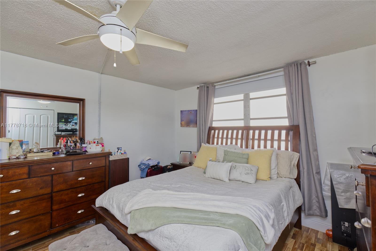 3195 Foxcroft Road, Unit F302 Miramar, FL 33025 - Photo 18 of 28 a bedroom with a bed and a dresser