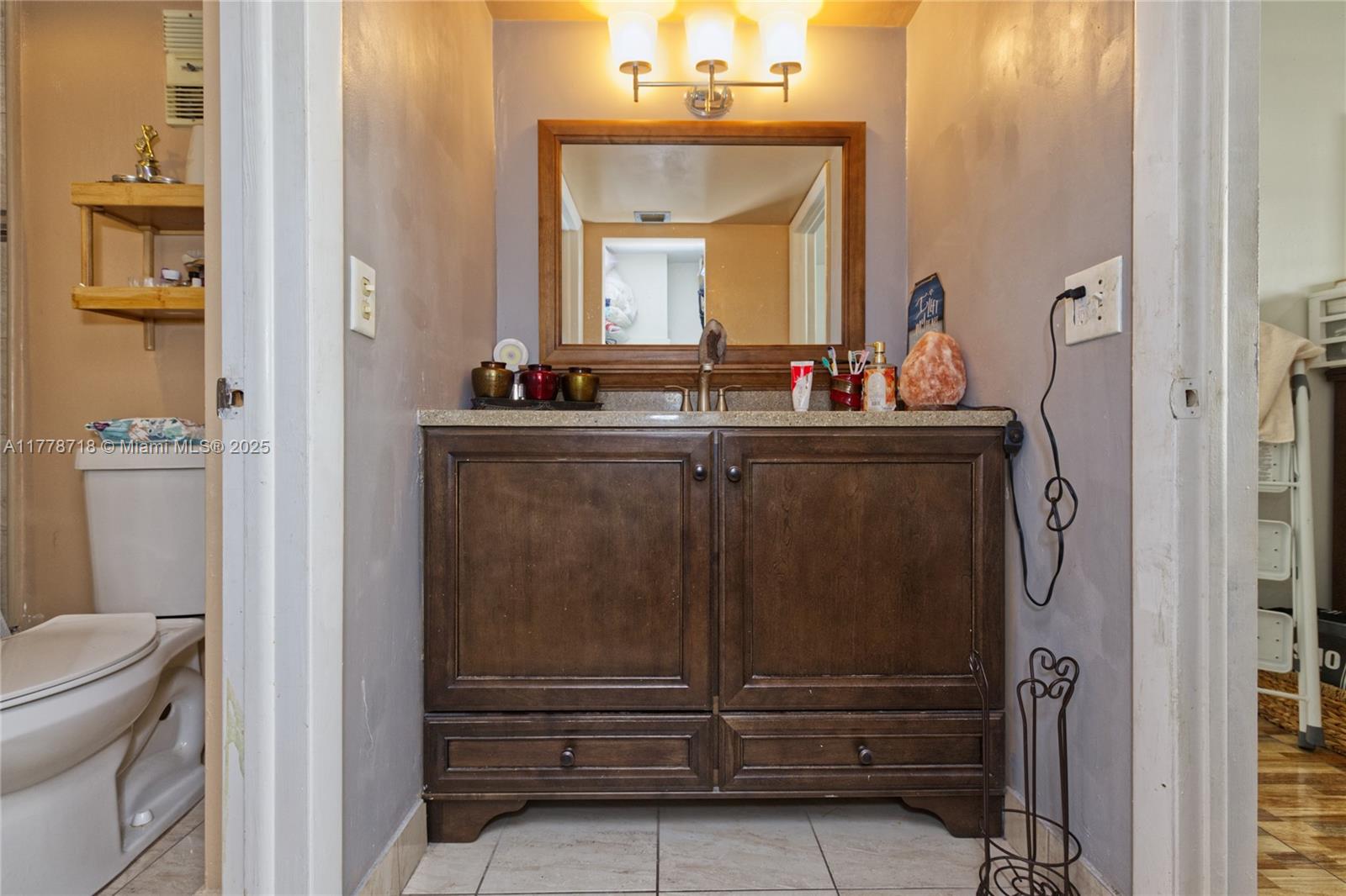 3195 Foxcroft Road, Unit F302 Miramar, FL 33025 - Photo 4 of 28 a bathroom with a sink a toilet and a mirror