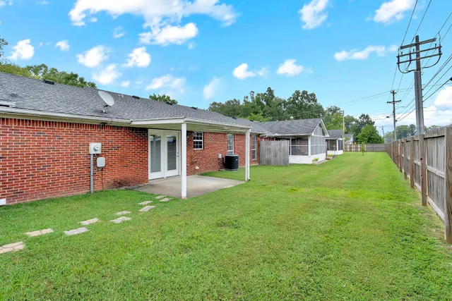 a view of a house with a yard and a tree