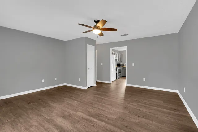 a view of empty room with wooden floor