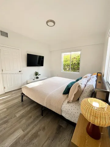 a bedroom with a bed and a flat screen tv