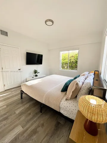 a bedroom with a bed and a flat screen tv