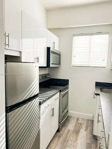 a kitchen with stainless steel appliances a refrigerator sink and microwave