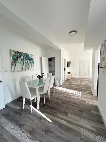 a view of a dining room with furniture a rug and wooden floor