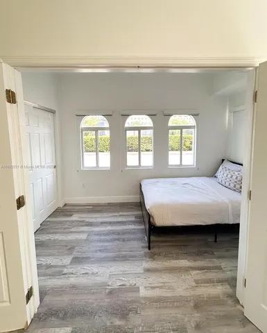 a bedroom with a bed and wooden floor