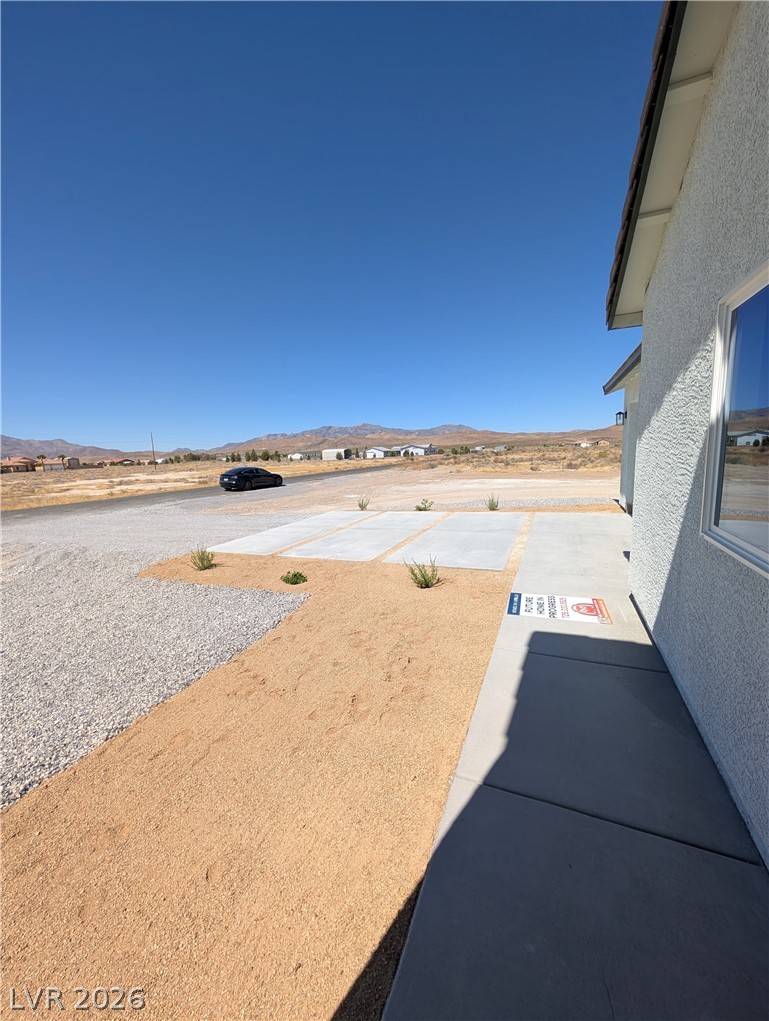 4670 Medicine Man Road Pahrump, NV 89048 - Photo 34 of 36 A well-maintained gravel driveway and walkway lead to this desert home with mountain views.