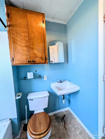 a bathroom with a toilet a sink and a window