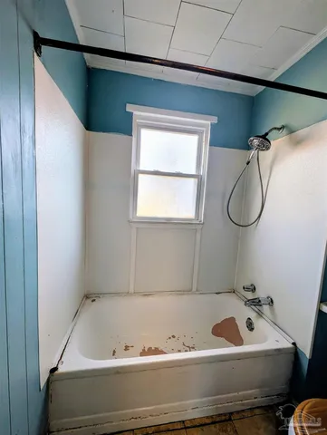 a bathroom with a tub and a window