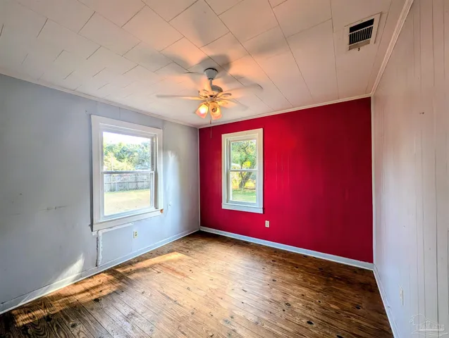 an empty room with windows and fan