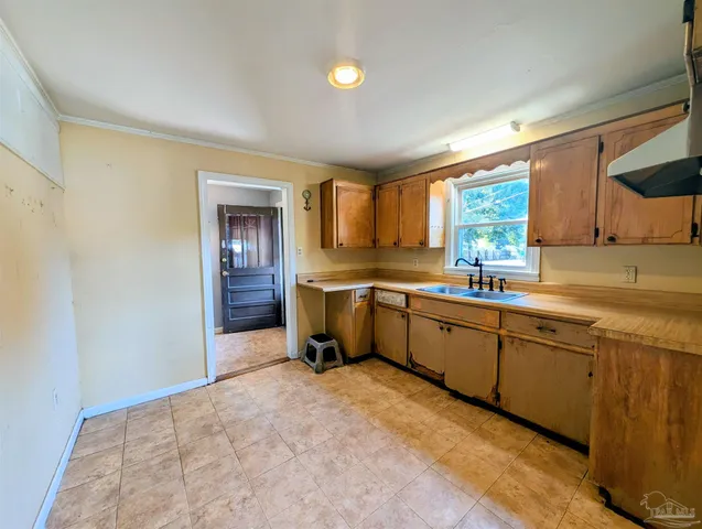 a large kitchen with a sink and cabinets