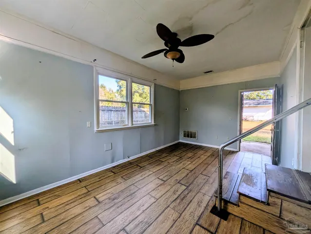 a view of empty room with wooden floor