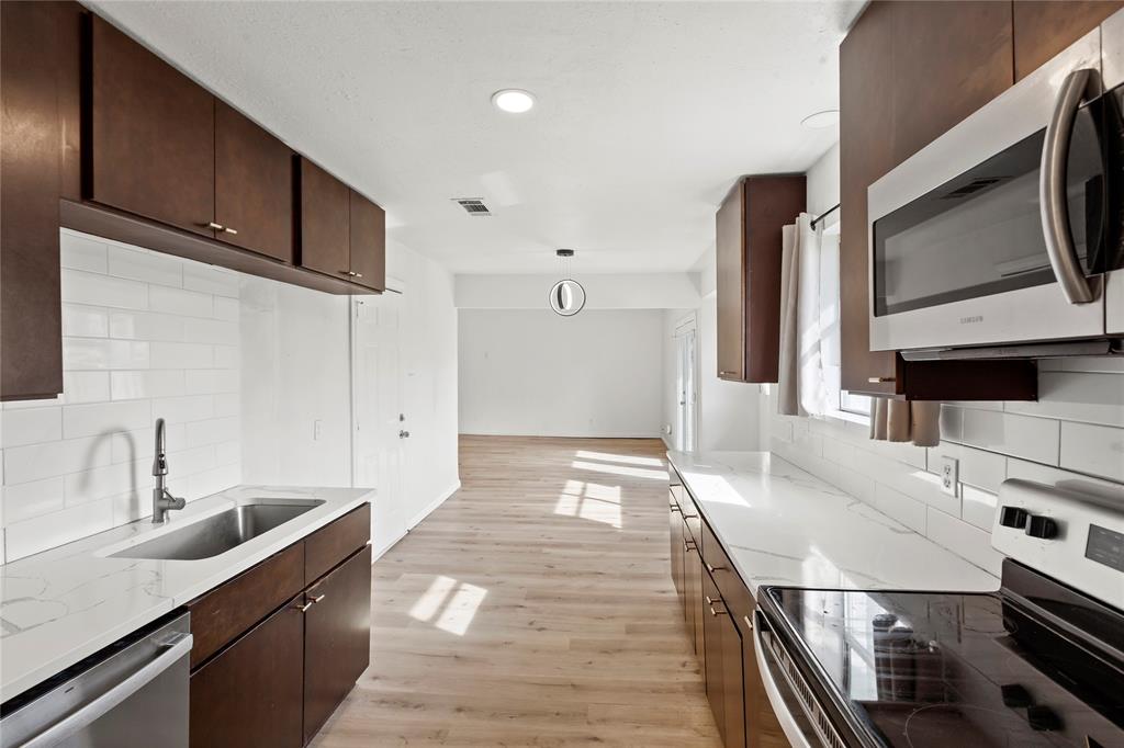 1012 East Dallas Street Mansfield, TX 76063 - Photo 11 of 25 a kitchen with stainless steel appliances a sink a stove and cabinets