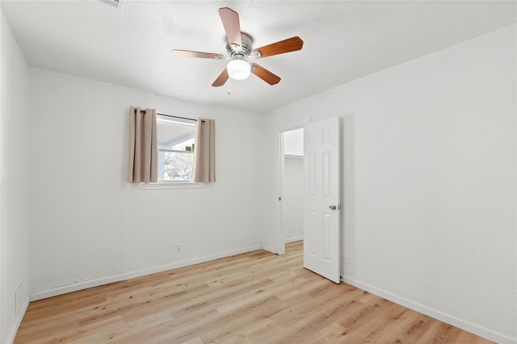 1012 East Dallas Street Mansfield, TX 76063 - Photo 19 of 25 an empty room with wooden floor ceiling fan and windows