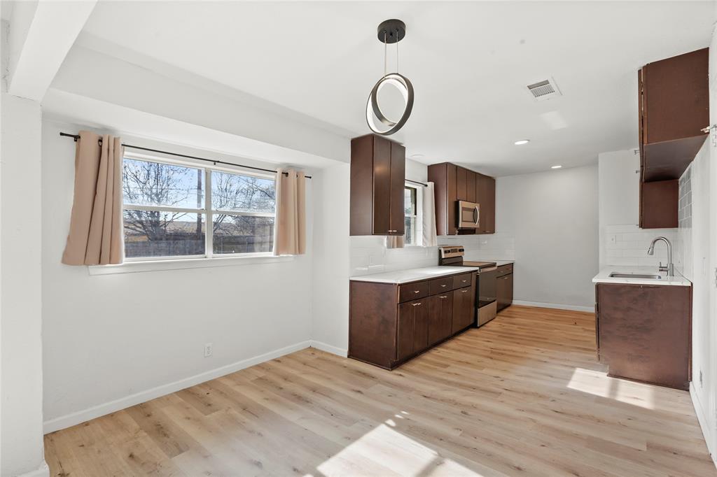 1012 East Dallas Street Mansfield, TX 76063 - Photo 8 of 25 a kitchen with stainless steel appliances granite countertop a sink dishwasher a stove and a refrigerator with wooden floor