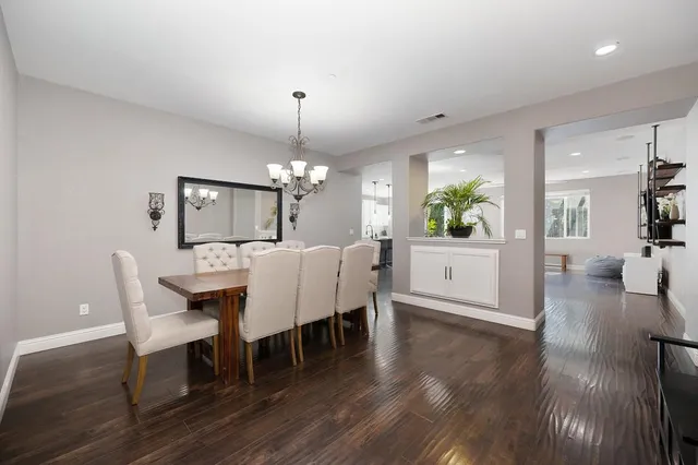 a view of a dining room with furniture a chandelier and wooden floor
