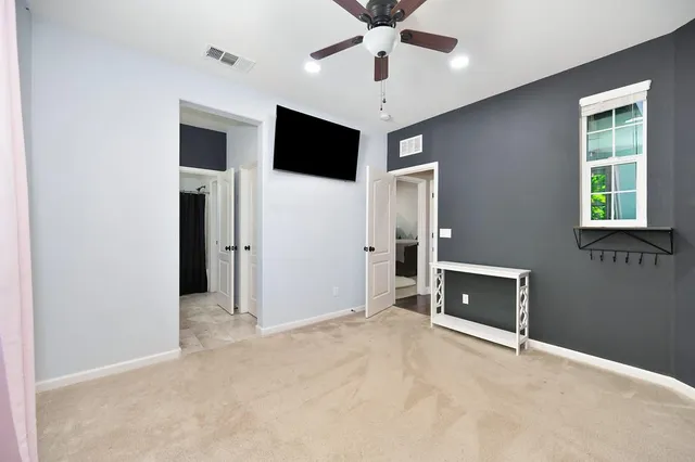 en empty room with windows and ceiling fan